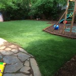 artificial grass lawn installed in backyard with playground and patio